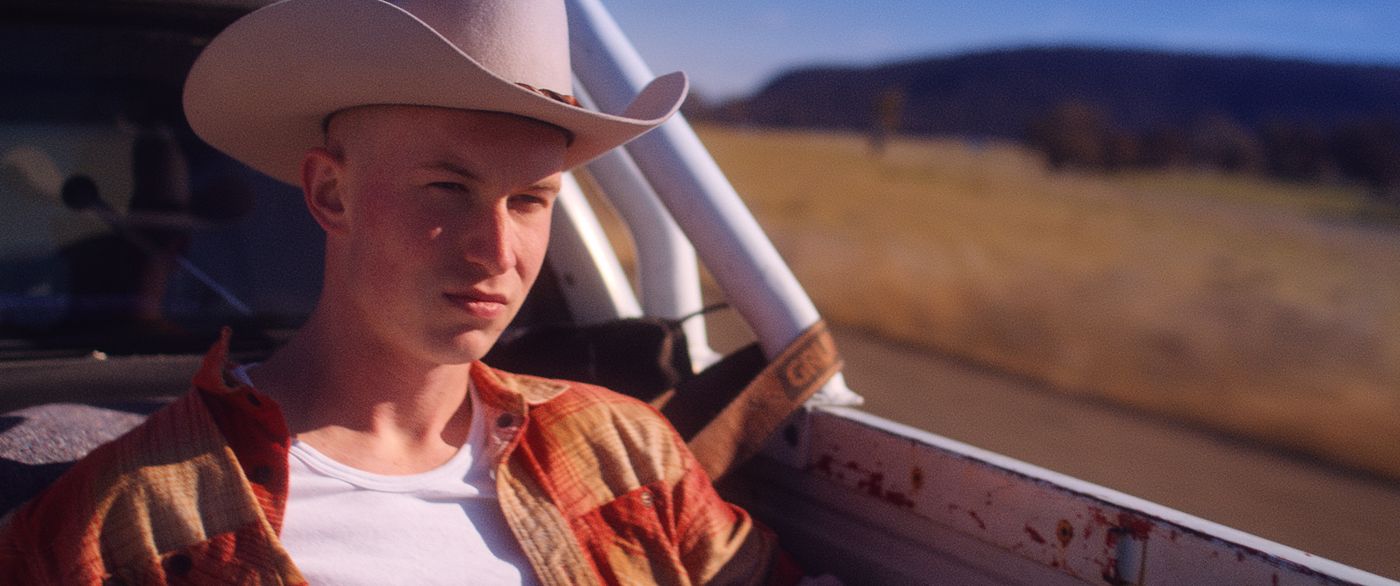 Lonesome — a young man in a truck bed wearing a cowboy hat