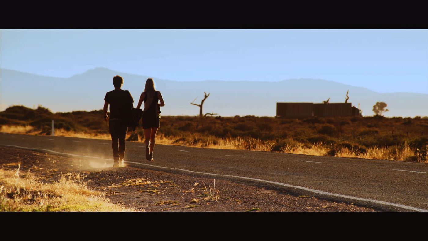 Road Train — figures walking down an outback highway toward a truck